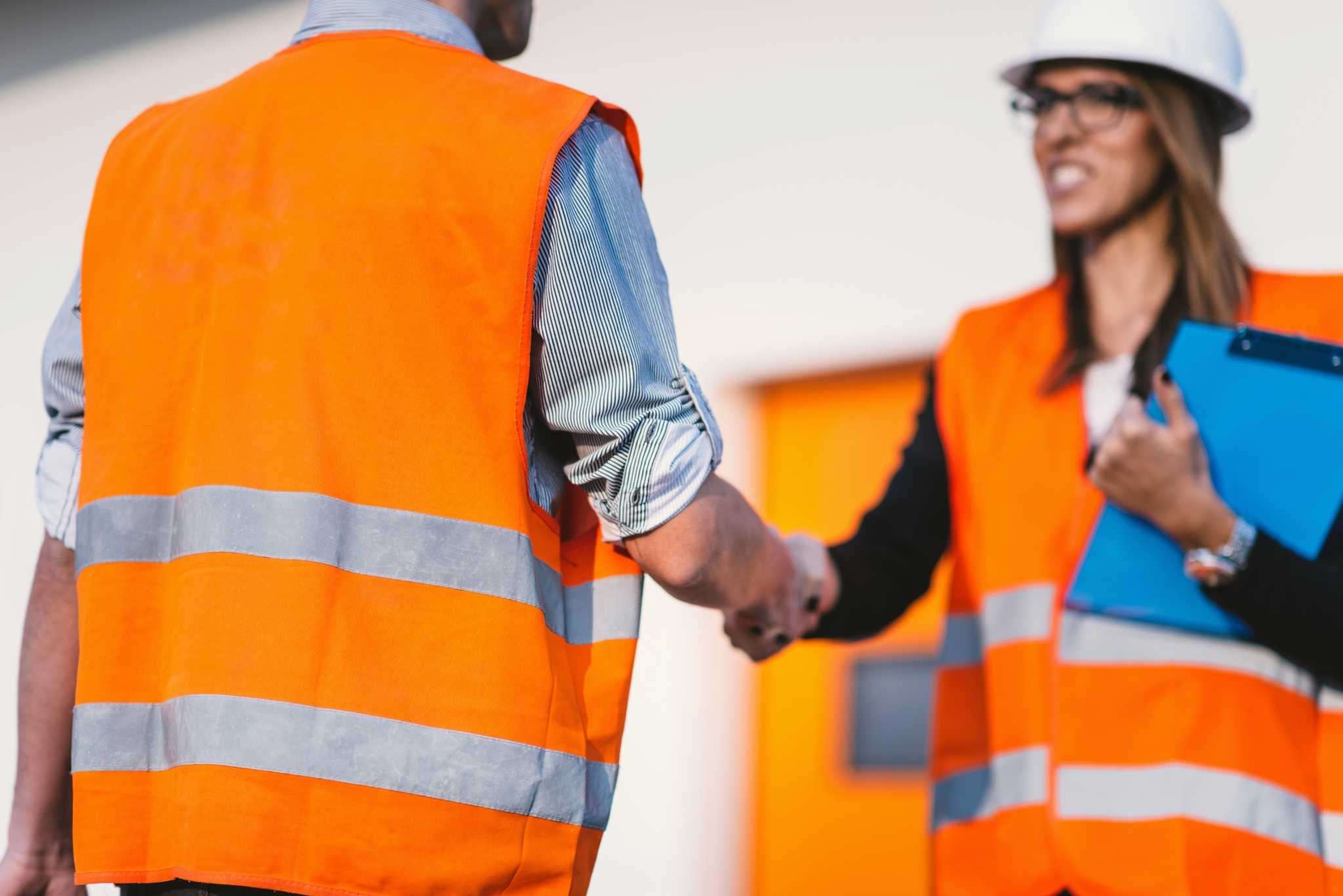 business handshake on construction site PELUDQW